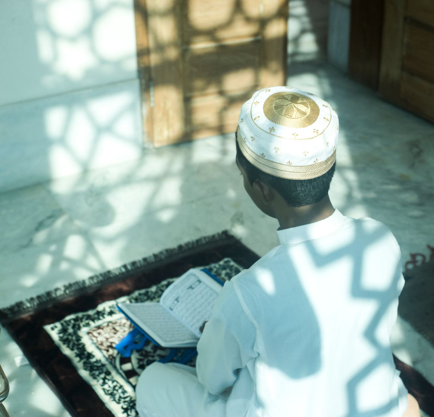 A young boy reading the Qur’an inside a mosque